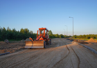 Roadworks. Motor Grader on road construction in forest. Greyder leveling the ground during roadworks. Heavy machinery and construction equipment for grading. Earthworks grader machine on Roadworks.