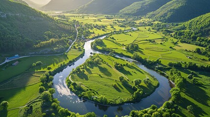 A serpentine stream meanders through lush hills.