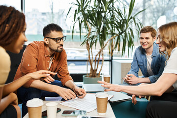 A dynamic group of colleagues from a startup team engaged in vibrant discussions around a table,...