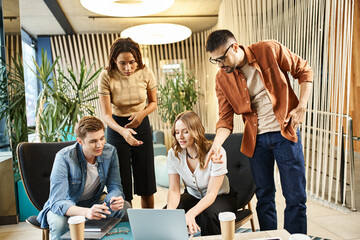 Colleagues in a coworking space, a startup team engaging in modern business strategy, huddling around a laptop for collaboration.