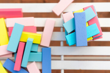 colored wooden bricks scattered on a brick red and white striped background