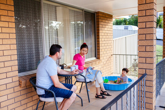 Happy Australian couple relaxing on front porch drinking tea together