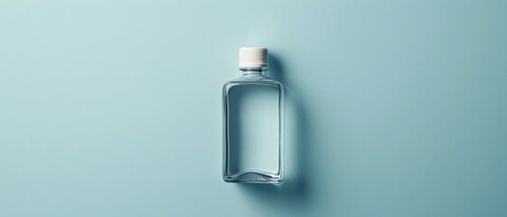 A clear glass bottle with a white cap on a light blue background.
