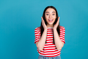 Photo of adorable impressed girl wear striped t-shirt smiling empty space isolated blue color background