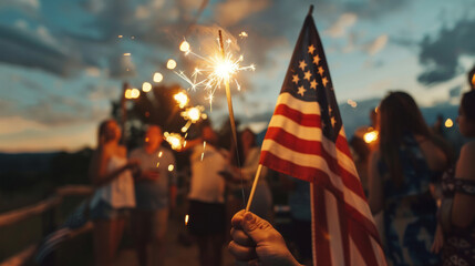Fototapeta premium Close up of a person holding an American flag and sparkler celebrating 4th July independence day