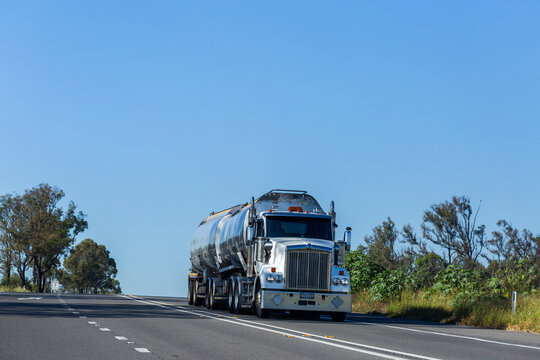 Truck traveling down highway with blue sky copy space above
