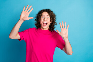 Photo of nice young man raise hands open mouth wear pink t-shirt isolated on blue color background