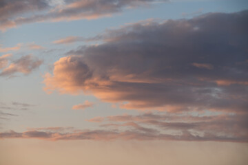 Photo background texture of clouds in the sky illuminated by the sun at sunset, close-up photo.