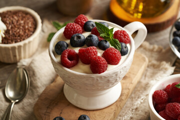 Cottage cheese blended with flax seed oil in a bowl, with fresh raspberries and blueberries. Budwig diet.