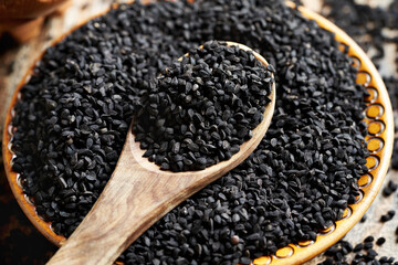 Black cumin or Nigella sativa seeds in a bowl and on a spoon