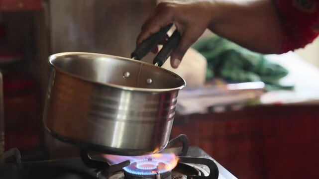 Indian style Hot Milk teachai, Selective Focus is used.Masala tea in iron pan with fire background,stone stove in Kolayat cattle fire Indian style Hot Milk teachai,making chai over a fire outside