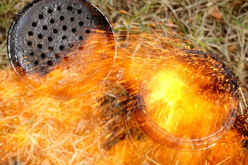 Close up of a beekeepers smoking equipment with smoke and fire coming out of the nozzle

