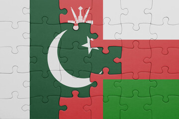 puzzle with the colourful national flag of oman and flag of pakistan .