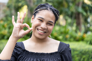 Smiling Young plus-size African Woman Expressing Agreement with OK hand Gesture, concept image of Encouragement, Support, Agreement, Satisfaction, Acceptance, Consent, Agreeing expression