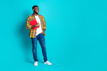 Fototapeta premium Photo of nice cheerful young man wear trendy checkered clothes standing empty space isolated on cyan color background