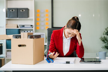 young beautiful Asian woman office worker celebrating her resignation, carrying her personal stuff.