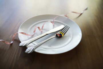 Diet Concept with Empty Plate, Measuring Tape, and Restricted Food Representation