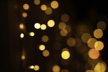 Obraz premium Blurred Festive Golden Bokeh Lights Background with Warm Holiday Glow