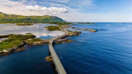An aerial view of a bridge winding through a picturesque fjord in Norway, showcasing the stunning natural beauty of the region. Atlantic Ocean Road Norway