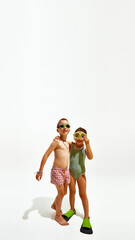 Poster. Boy and girl, ready for swim, pose together in swimwear against white studio background with copy space. Concept of hot summer holidays, vacation, camps, recreation.