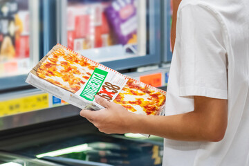 Man buying Italian pizza in chilled food section
