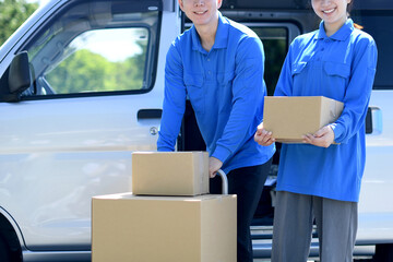 荷物を運ぶ配送ドライバーのアジア人の男女