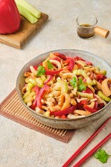 Salad from squid, sweet pepper and celery in the Asian style in a ceramic bowl on a light concrete background. Receptam -products, squid.