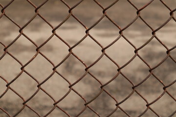 Rusty chain the fence. The texture of the fence can symbolize decay or boundaries.