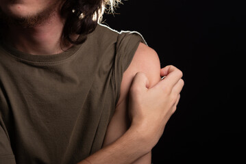 Man scratching his shoulder with his hand. Skin disease. Irritation, allergy.