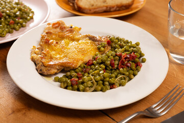 Delicious crispy chicken with peas as a side dish on a plate
