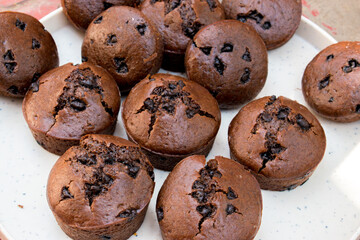 Close up of mini chocolate cupcakes on white plate . selective focus