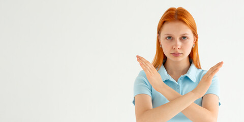 Young caucasian woman wearing blue t-shirt over white background Rejection expression crossing arms...