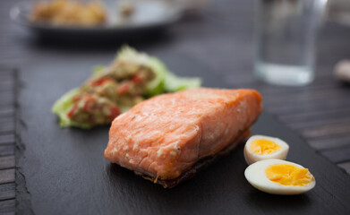 Baked salmon fillet with homemade guacamole and quail eggs halves