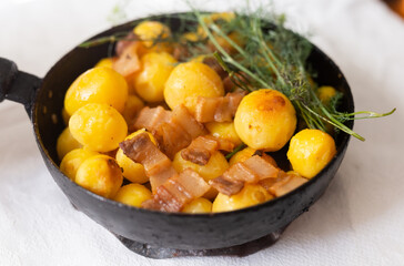 Delicious freshly cooked roasted new potatoes with bacon served in a frying pan