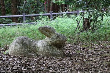 Side of an old stone statue of a rabbit in the park
