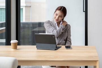 Beautiful Asian businesswoman stretching From working hard in the office