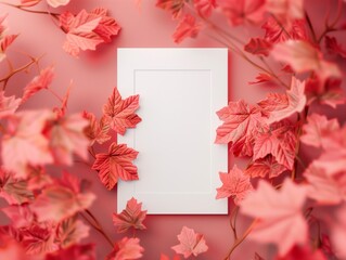 Obraz premium White frame surrounded by autumn leaves on red backdrop.