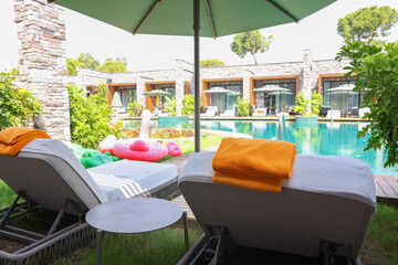 Sunbeds near outdoor swimming pool at luxury resort