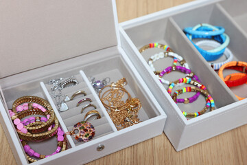 Jewelry boxes with stylish bracelets and other accessories on wooden table