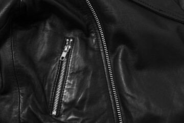 Texture of black leather jacket with zipper as background, top view