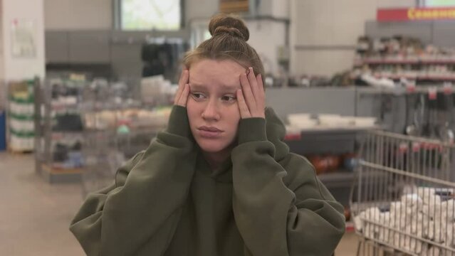 Sad frustrated woman in the grocery store dissatisfied because of high prices. 