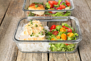 Healthy meal. Containers with different products on wooden table, closeup