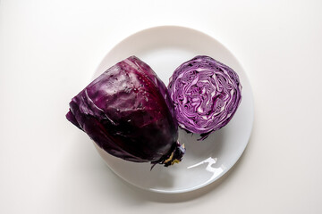 Red cabbage on a large white plate. Cut red cabbage on a white background.