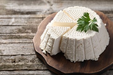 Tasty ricotta (cream cheese) on wooden table, closeup. Space for text