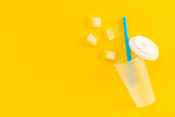 Disposable cup with ice and straw for cocktails. Cold drink concept