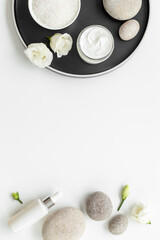 Blank white bottles of skin care cosmetics with roses