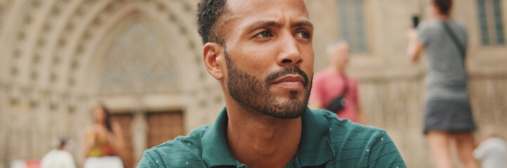 Fototapeta premium Close up, young man sitting on the steps of the Sagrada Familia in Barcelona