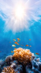 Naklejka premium Sunlight streams through crystal clear water, illuminating vibrant coral and a school of fish swimming in a tropical reef.