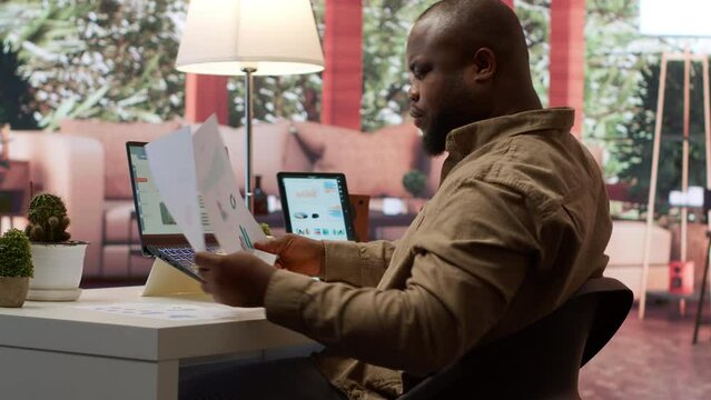 Business owner reviewing key performance indicators within the enterprise activity, remote work at home. Conducting evaluations to help with global expansion, finance and economy. Camera A.