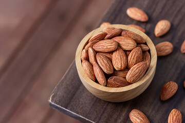 Almond snack fruit in wooden bowl blur background, Top view